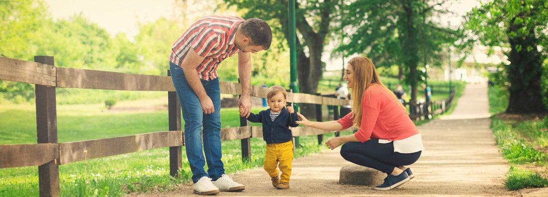 Parents and their baby boy learning to walk