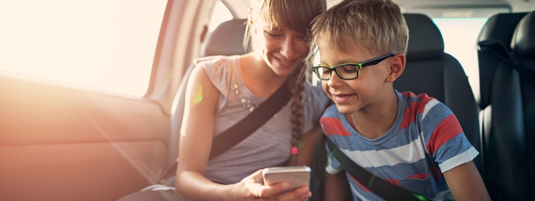 Kids playing smartphone during a road trip