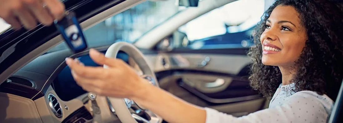 Car dealer is giving key for a new car to a businesswoman. How to Find the Best Car Insurance Policy in Moorestown, NJ.