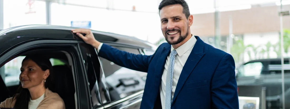 Car salesman with customer on car dealership. Car Add Ons: Should You Buy? Should You Pass?