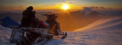 Snowmobile rider at sunset