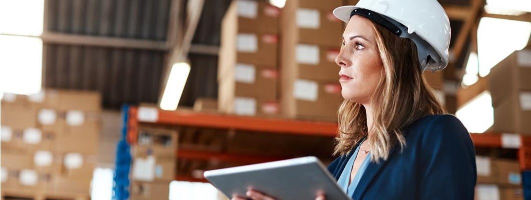 Woman using a digital tablet while working in a warehouse. Finding the Best Contractor Equipment Insurance.
