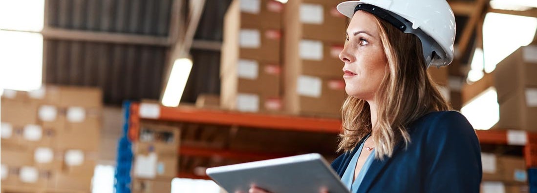 Woman using a digital tablet while working in a warehouse. Finding the Best Contractor Equipment Insurance.