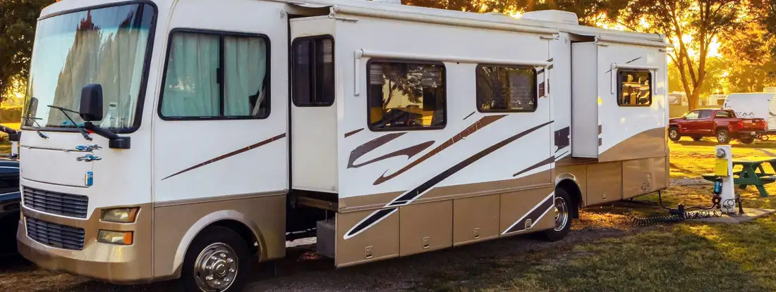 Rv motorhome parked at campsite. Find Class A Motorhome Insurance.