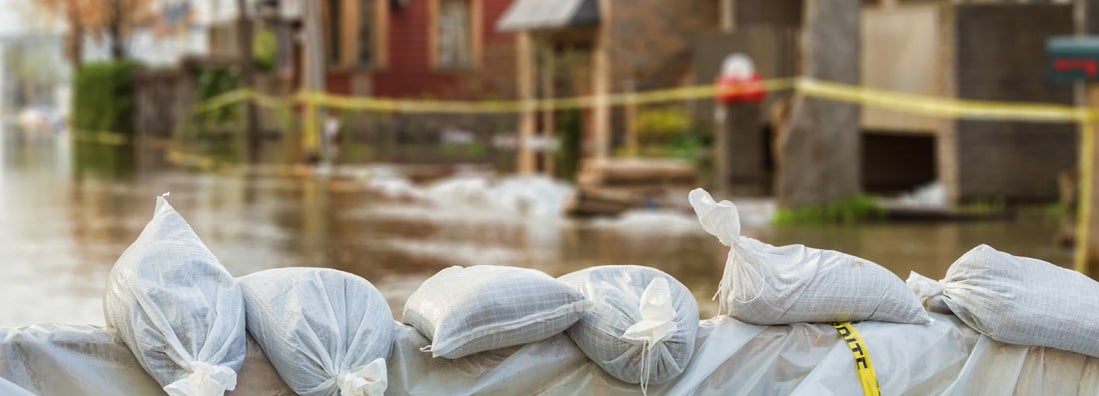 Flood Protection Sandbags with flooded homes in the background