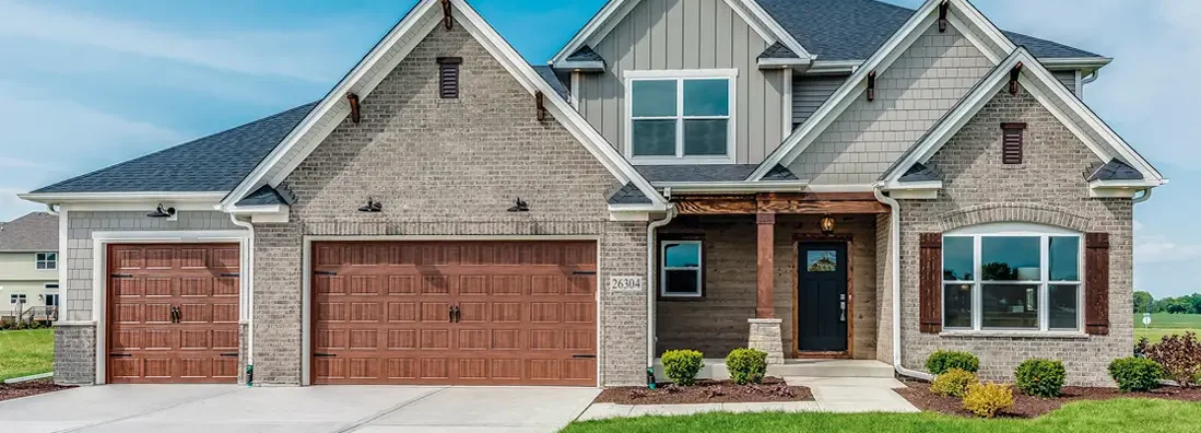 Brown three car garage with olive paint on the rest of the house. How to Find the Best Homeowners Insurance in Florissant, Missouri.