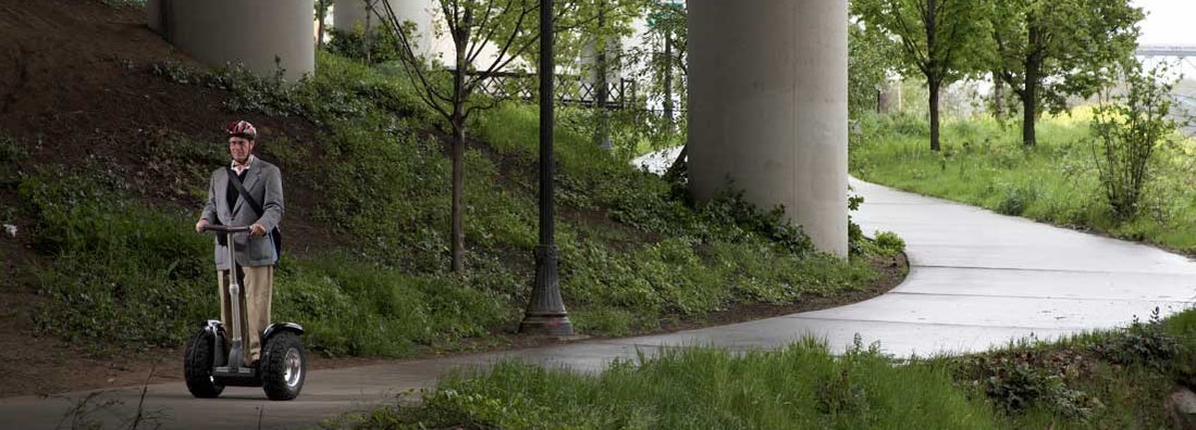 Senior man riding segway under underpass. Find Segway Insurance.