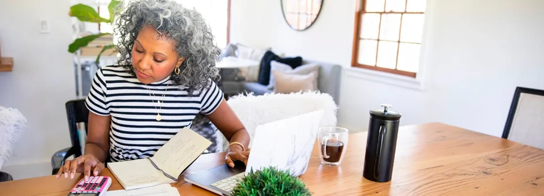 Mature Woman Working at Home on laptop. Get Coppell, Texas Business Insurance.
