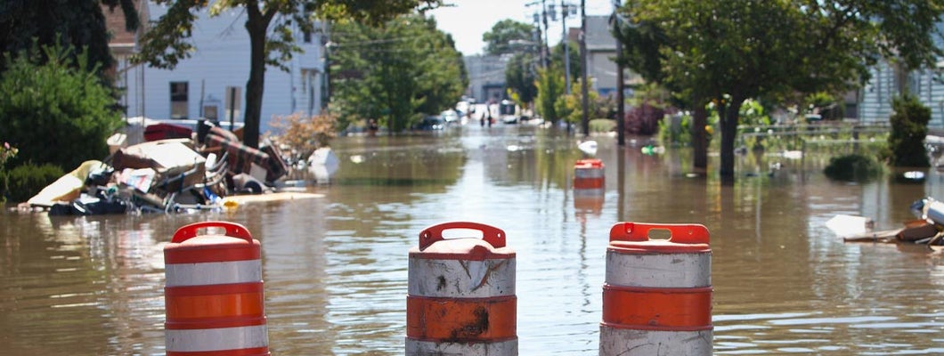 Orange blockade cones on a flooded street. Find Washington flood insurance.