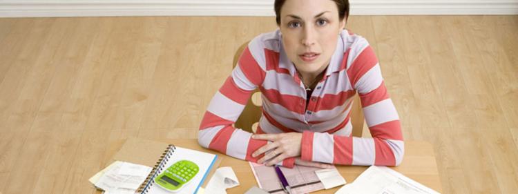 A woman going over paperwork looking stressed.