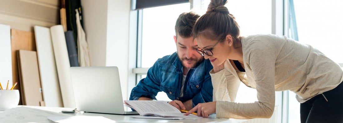 Two coworkers looking at paper document. Find Scottsdale, Arizona business insurance.