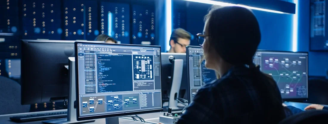 IT Programer Working on Desktop Computer in Data Center System Control Room. Find cyber liability insurance.