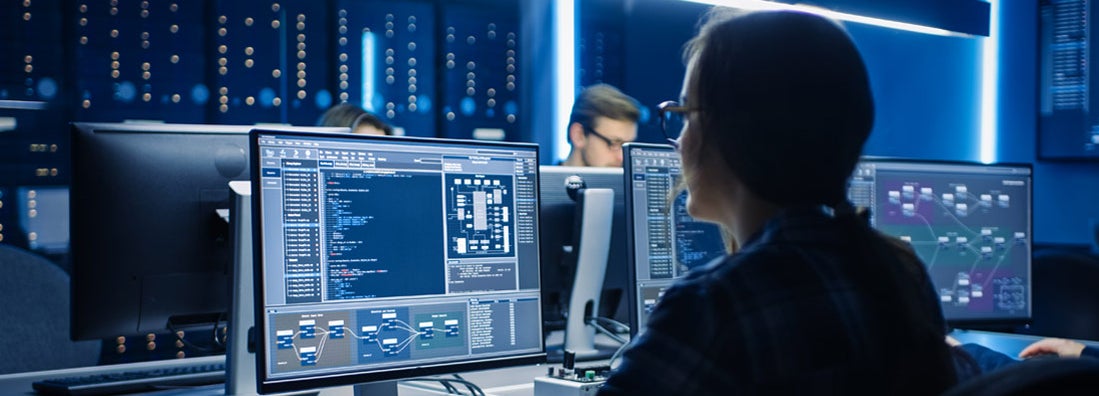 IT Programer Working on Desktop Computer in Data Center System Control Room. Find cyber liability insurance.