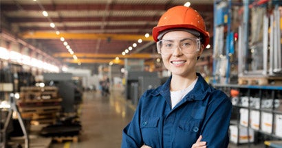 Woman with orange helmet in factory warehouse. Workers Compensation for Businesses 
