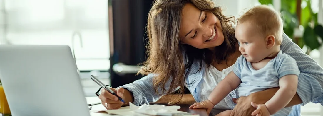 Happy mother talking to her baby while working at home. Why Is Insurance More Expensive In New Jersey?