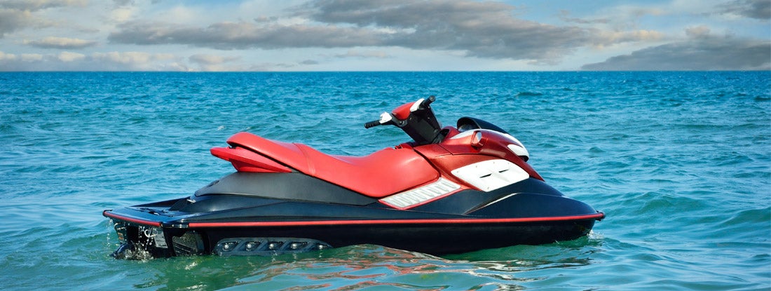 Jet-ski on waves of the sea against the blue sky