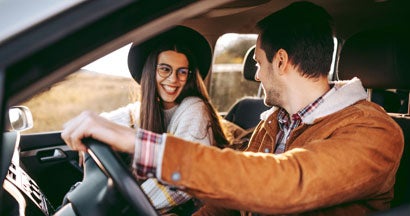 Young couple enjoying a road trip together . Home and Auto Insurance for Unmarried Couples.