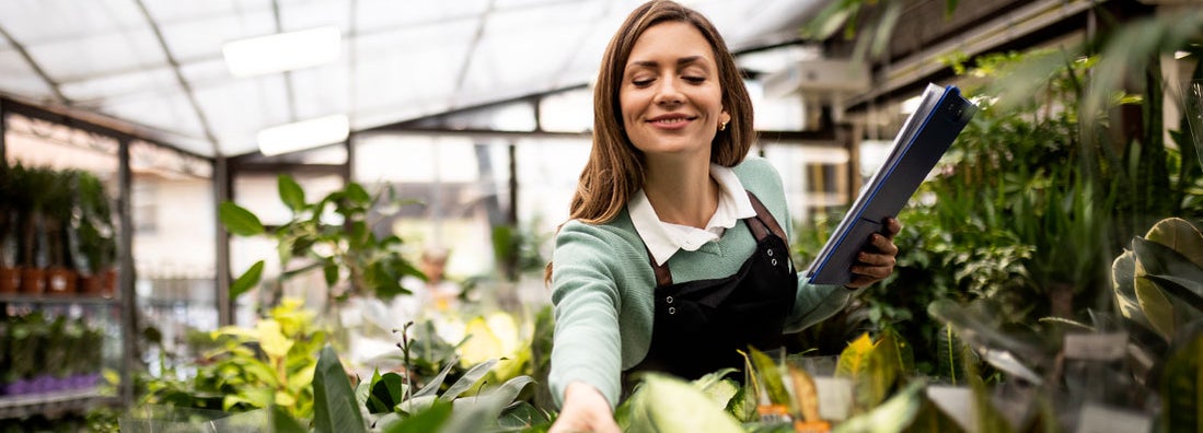 Smiling female florist at garden center. How much does small business insurance cost?