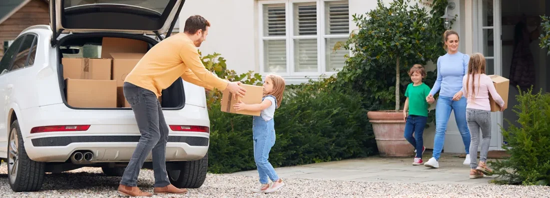 Family Outside New Home On Moving Day Unloading Boxes From Car. Oregon Umbrella Insurance That's Affordable. 