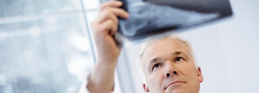 Male Doctor Examining An X-Ray Image. Find Podiatrist Malpractice Insurance.