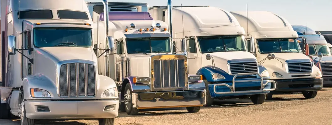 Generic semi-trucks in a parking lot. Find Commercial Fleet Insurance.