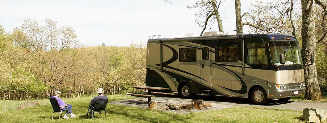 Couple relaxing near RV in Mississippi. Find Mississippi RV Insurance.