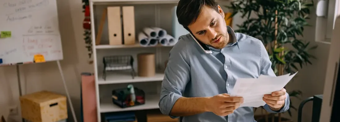 Businessman talking over mobile phone in small office. West Fargo, North Dakota business insurance.