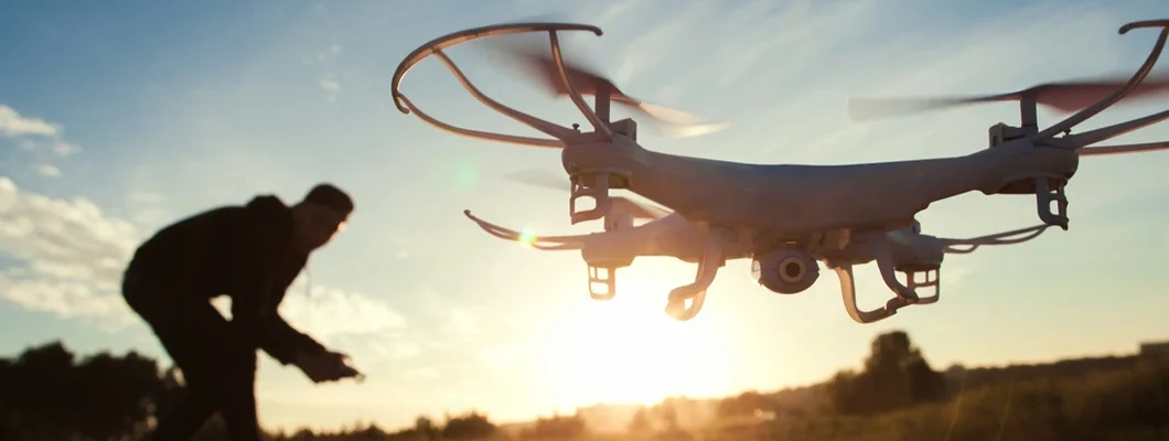 Pilot running drone at sunset light. Find Drone Insurance.