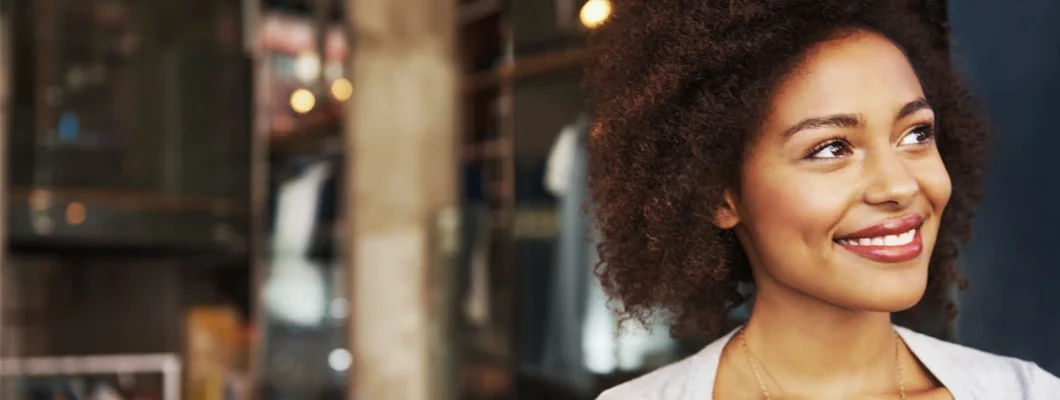 Smiling ethnic woman standing outside coffee house. Business Insurance Cost. 