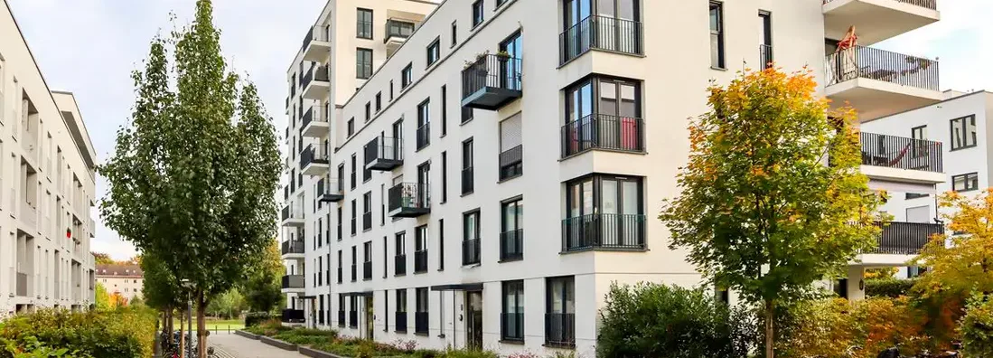 New apartment buildings and green courtyard with pavement and trees in autumn. Find Pennsylvania renters insurance.