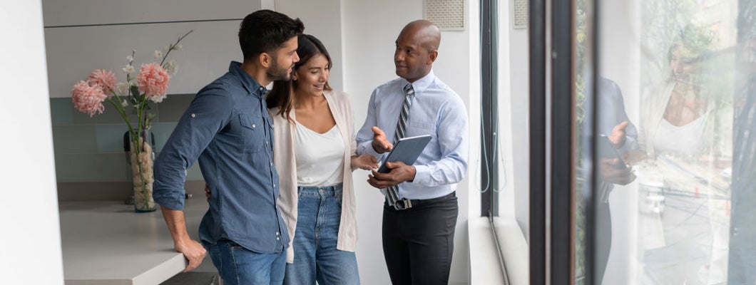 Landlord talking to a couple buying an apartment. Find Illinois Landlord Insurance.