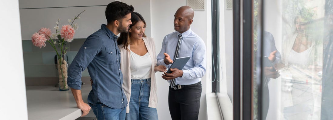 Landlord talking to a couple buying an apartment. Find Illinois Landlord Insurance.