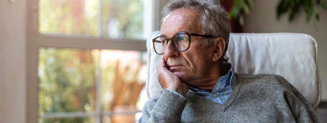 Senior man looking out of window at home. Missing Life Insurance Policy.