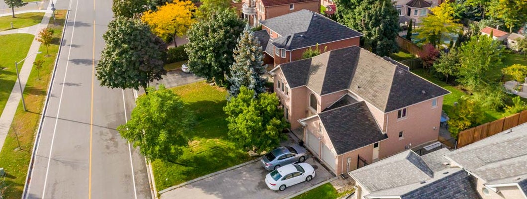 Aerial view of home and cars in driveway. Find New York Umbrella Insurance.