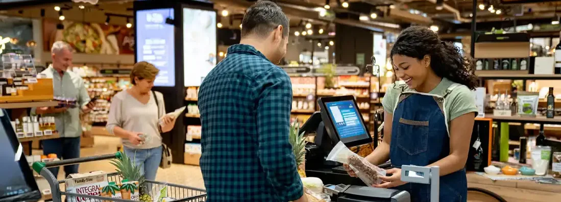 Cashier working at the supermarket registering products. Find Grocery Store Insurance.