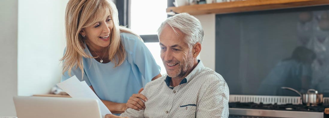 Mature couple smiling while calculating annuity interest rates together