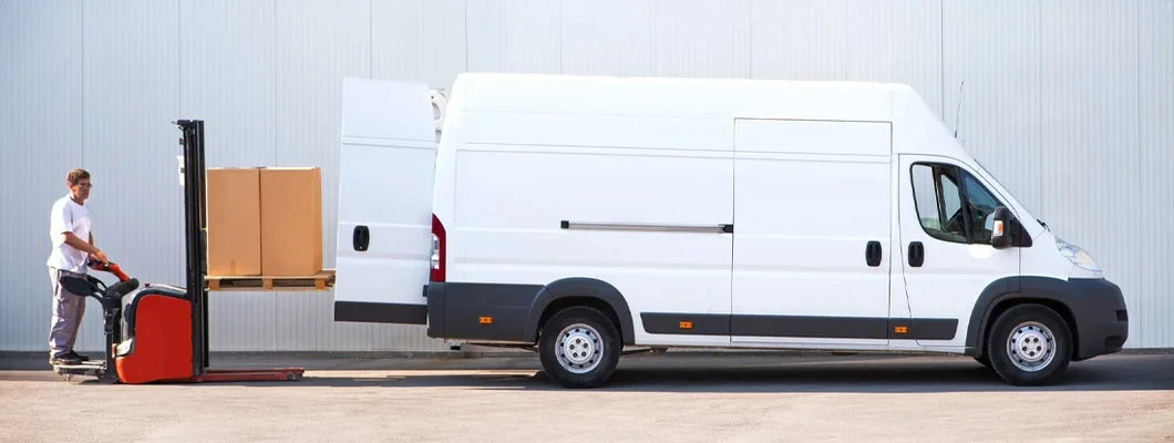 Courier is loading the van with parcels. Find Minnesota Commercial Vehicle Insurance.