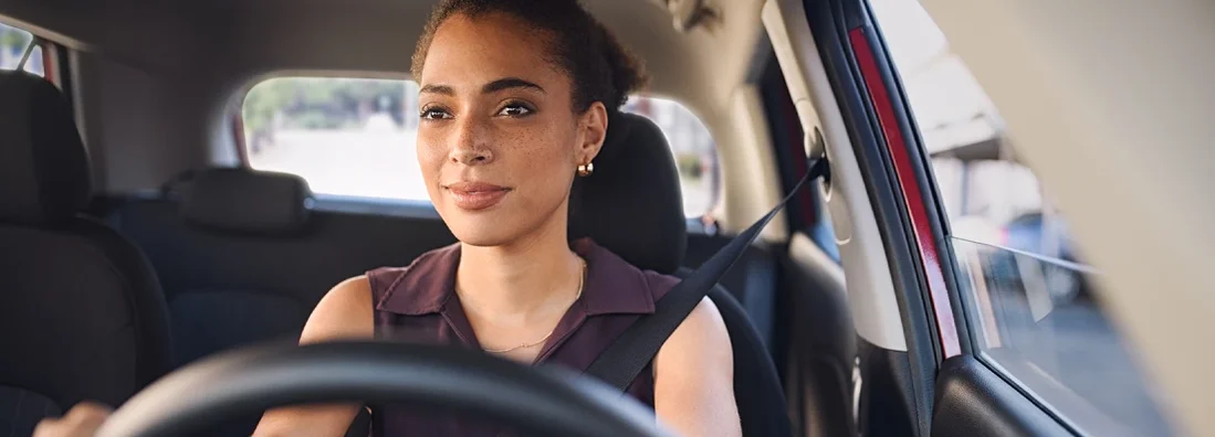 Business woman driving car in city streets. Why Are Car Insurance Rates Going Up in 2023?