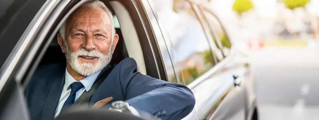 Senior businessman sitting in his car on daily commute. Find Troy, Michigan car insurance.