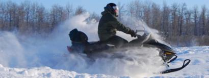 Snowmobile rider on a forest trail