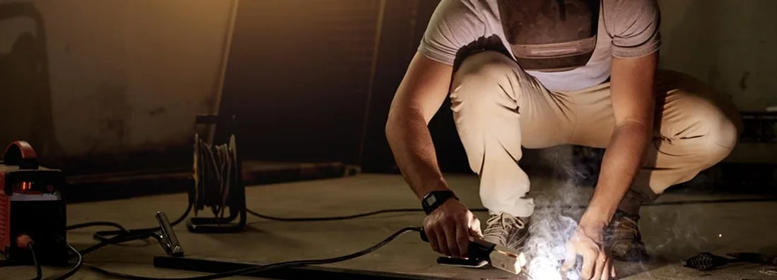 Young welder working in his workshop. Find Welding Contractor Insurance.