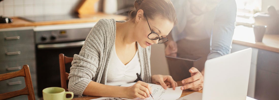 Photo of a young couple calculating how much they can spend on a home