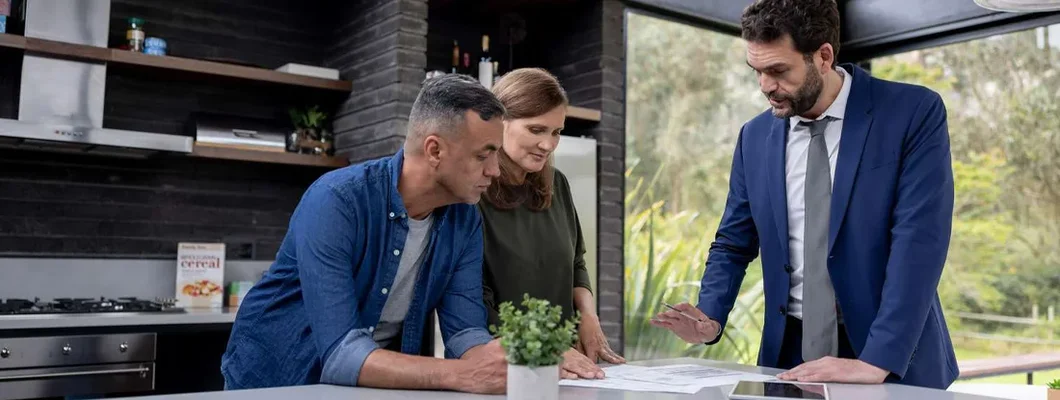 Financial advisor talking to a couple about their real estate investments. Find Maine Landlord Insurance.