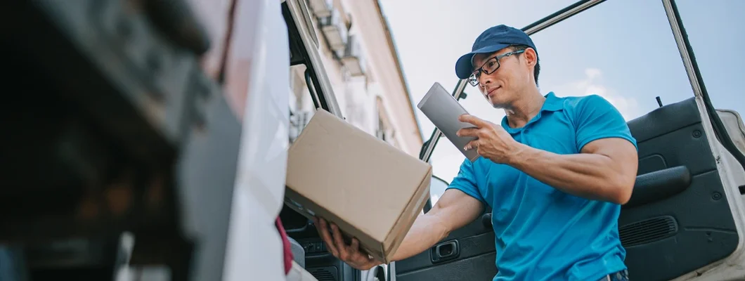 Delivery person scanning barcode on package cardboard box using digital tablet. Find Hawaii Commercial Auto Insurance.