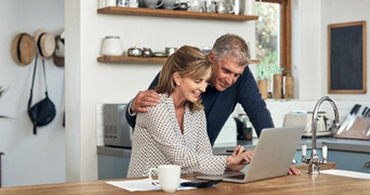 A senior couple researching car insurance using a laptop at home. How to shop for car insurance.