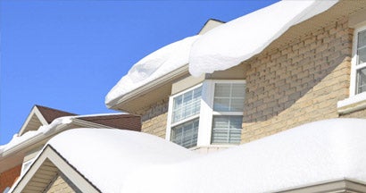Closeup of snow pile up on a roof. What kind of snow damage will homeowners insurance cover? 