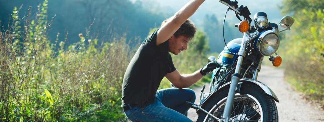 Young handsome male biker preparing to ride. Classic & Vintage Motorcycle Insurance.