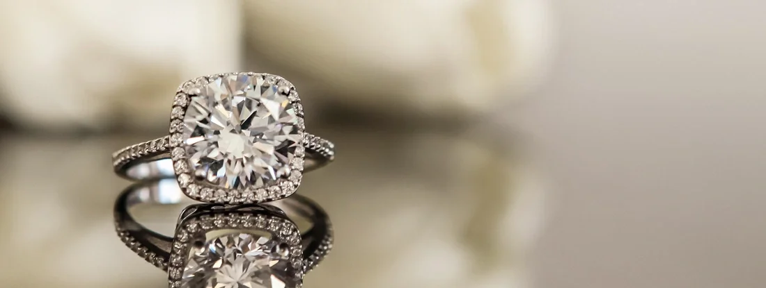 White gold wedding ring on flower background. What you need to know about insuring an engagement ring.