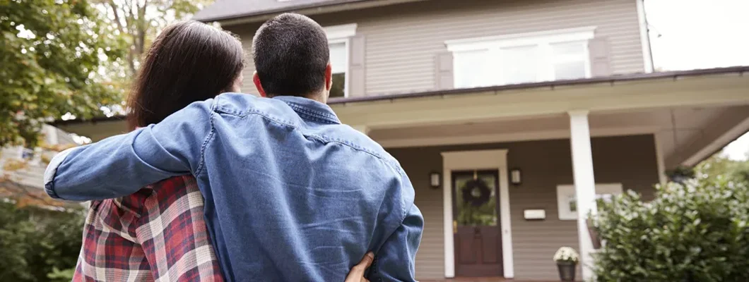 Rear View Of Loving Couple Looking At House. Top 12 Things You Wish You Knew Before Buying Your First House. 