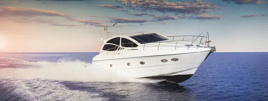 Luxurious motor boat sailing the sea at sunset. Find Boat Insurance Discounts.